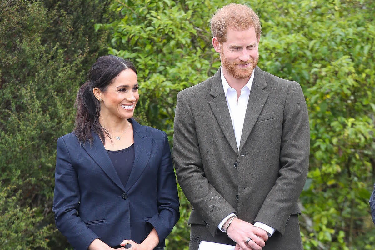 Meghan Markle, who held an umbrella in what could've been a 'dilemma' during a 2018 royal tour, stands next to Prince Harry
