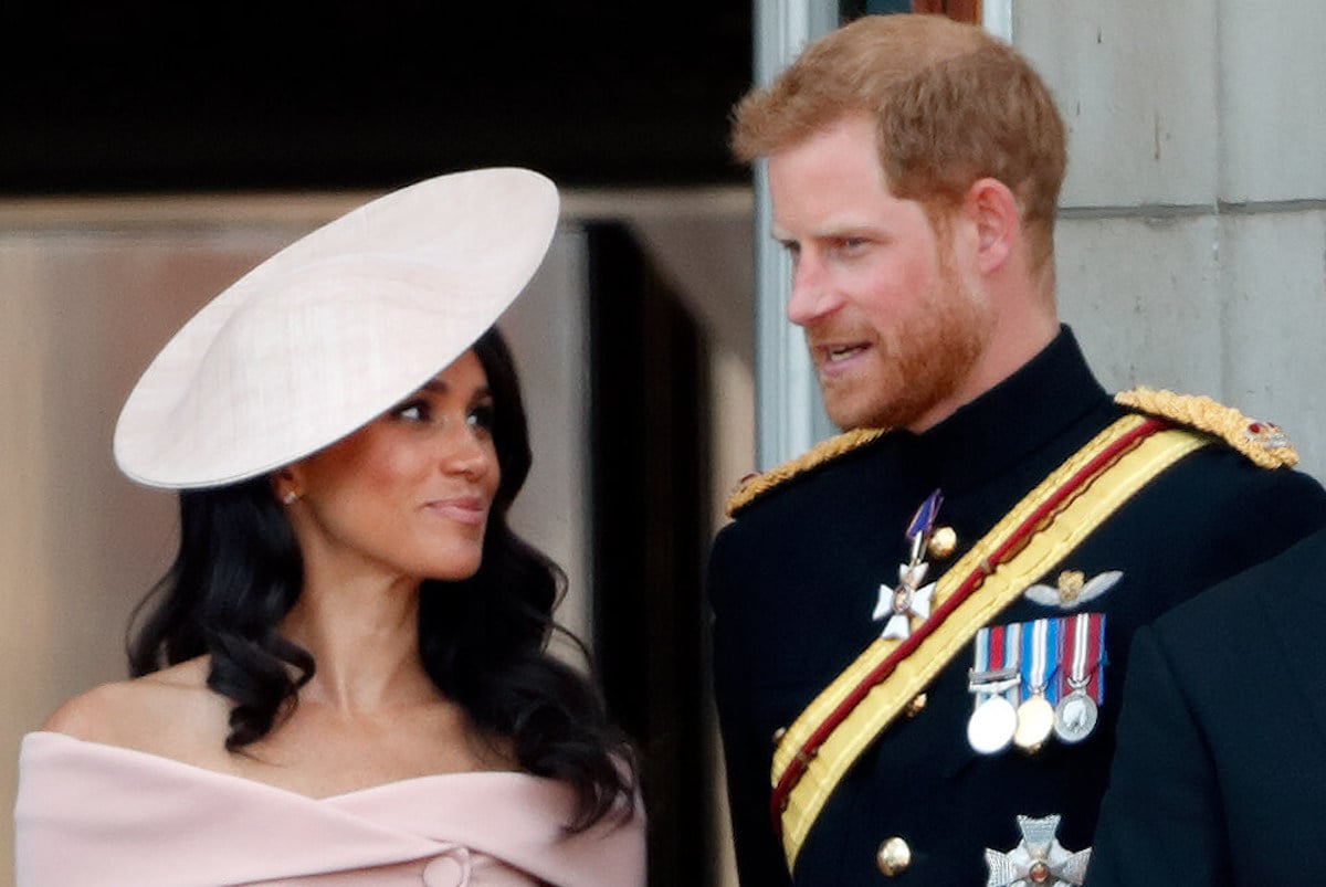 Meghan Markle, who, according to lip readers asked Prince Harry for help on navigating royal life, stands with Prince Harry