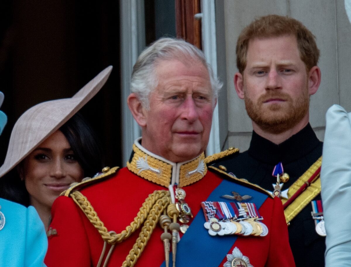 Meghan Markle, now-King Charles III, and Prince Harry standing on the Buckingham Palace balcony during Trooping the Colour 2018