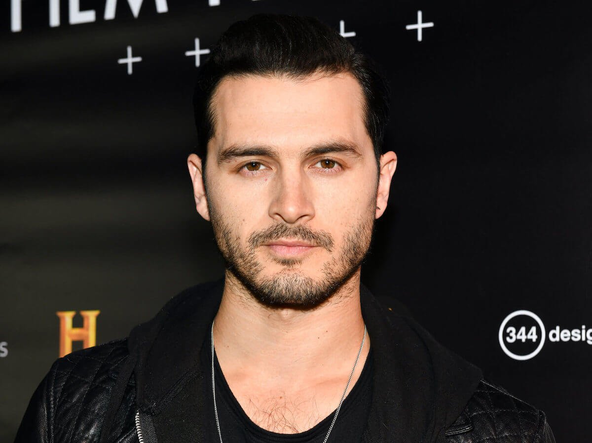 Michael Malarkey standing in front of a black backdrop