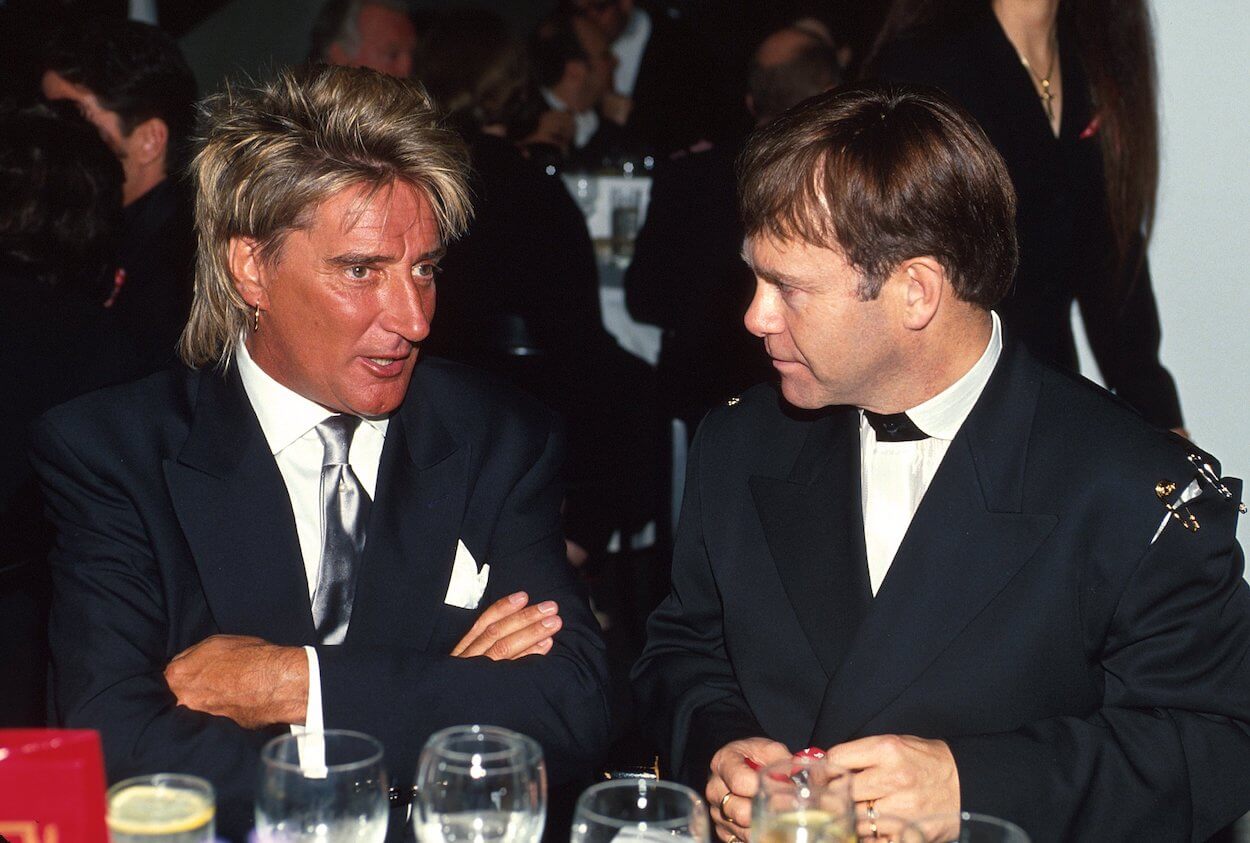 Rod Stewart (left) and Elton John talk to each other while wearing black suits at an event in Los Angeles in 1993.