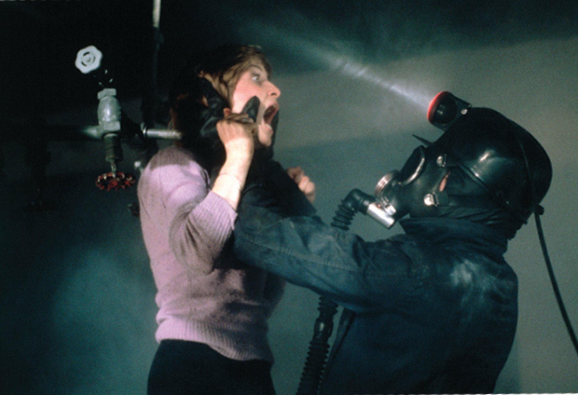 'My Bloody Valentine' Peter Cowper as Harry Warden and Helene Udy as Sylvia. Warden is holding Sylvia up by her face against a pipe.