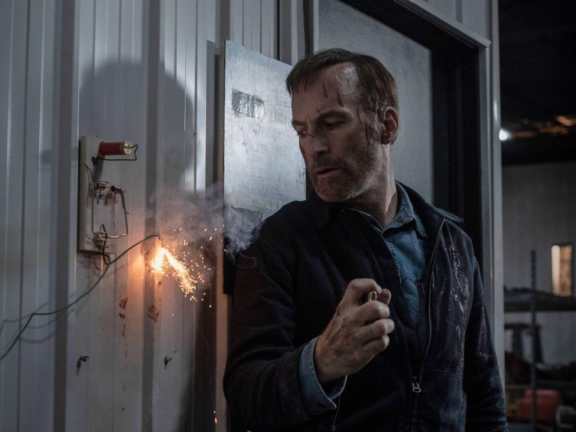 'Nobody' Bob Odenkirk as Hutch Mansell with his back against a wall and exposed wiring sparking.