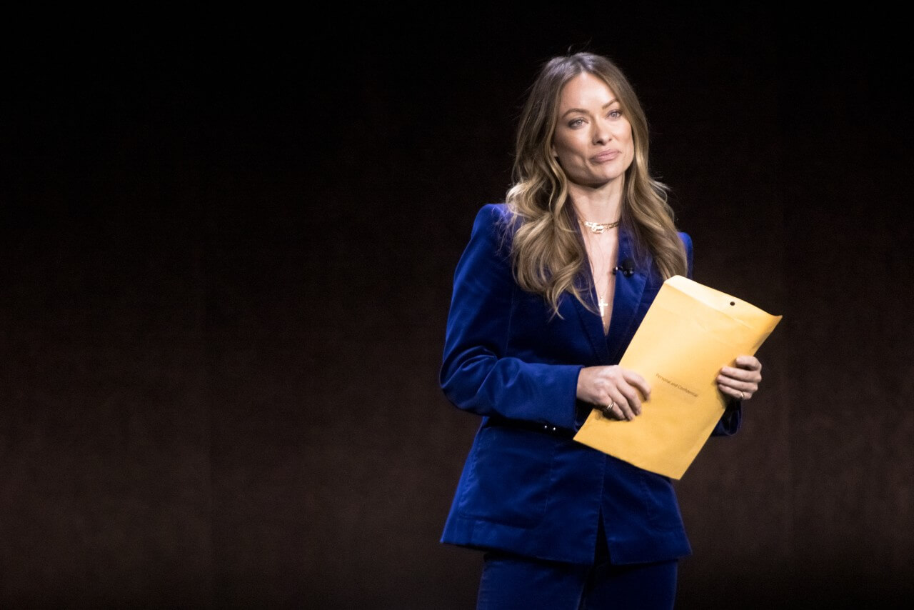 Olivia Wilde holds court papers in an envelope at CinemaCon. 