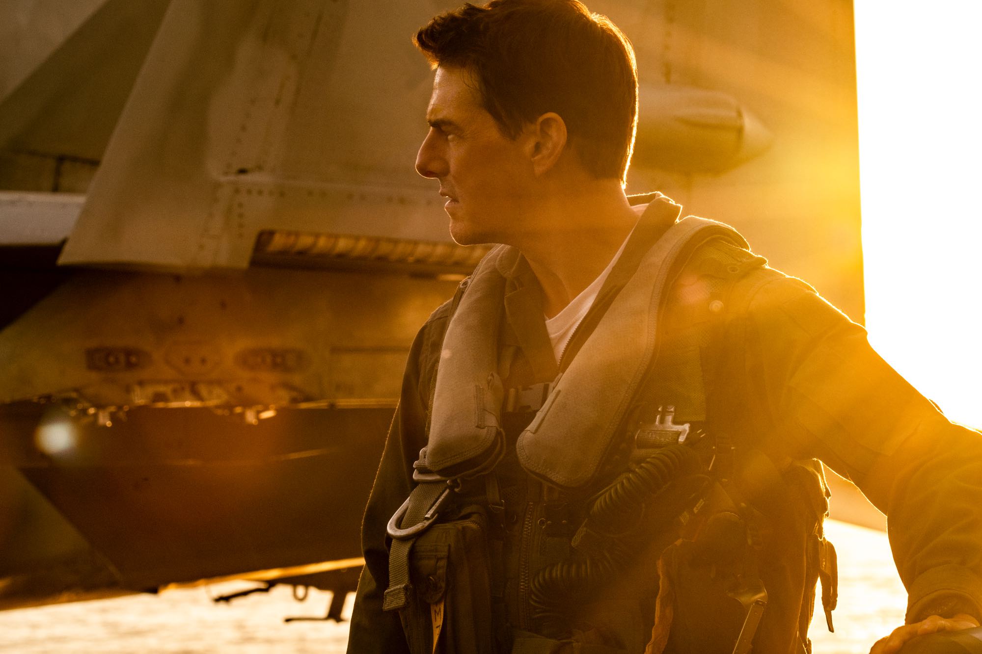 Oscars 2023 Best Picture nominee 'Top Gun: Maverick' Tom Cruise as Capt. Pete 'Maverick' Mitchell standing in front of a jet looking to the side, wearing his uniform