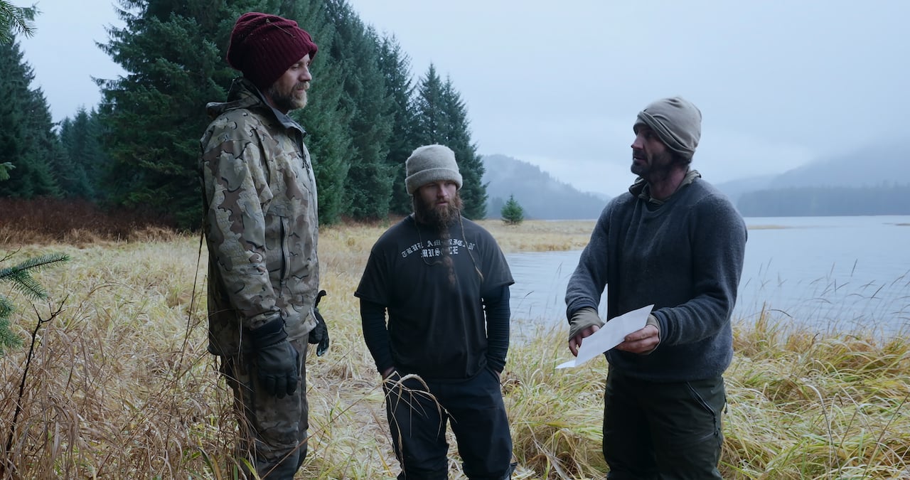 Paul Preece, Seth Lueker stand with Nick Radner, who is holding a piece of paper in Episode 6 of 'Outlast'.