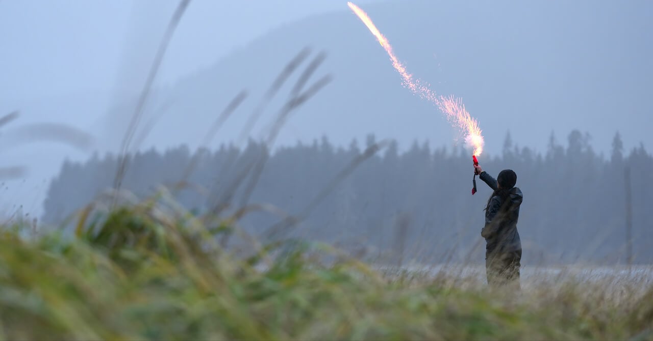 Someone shooting a flare in a field on 'Outlast'.