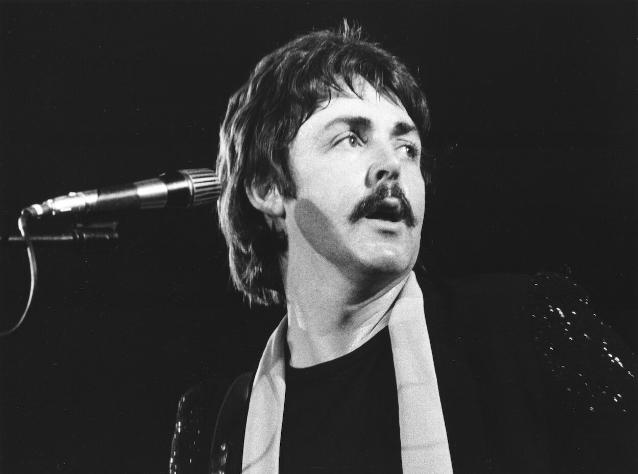 Paul McCartney looks to his left as he performs with his band Wings in 1976.