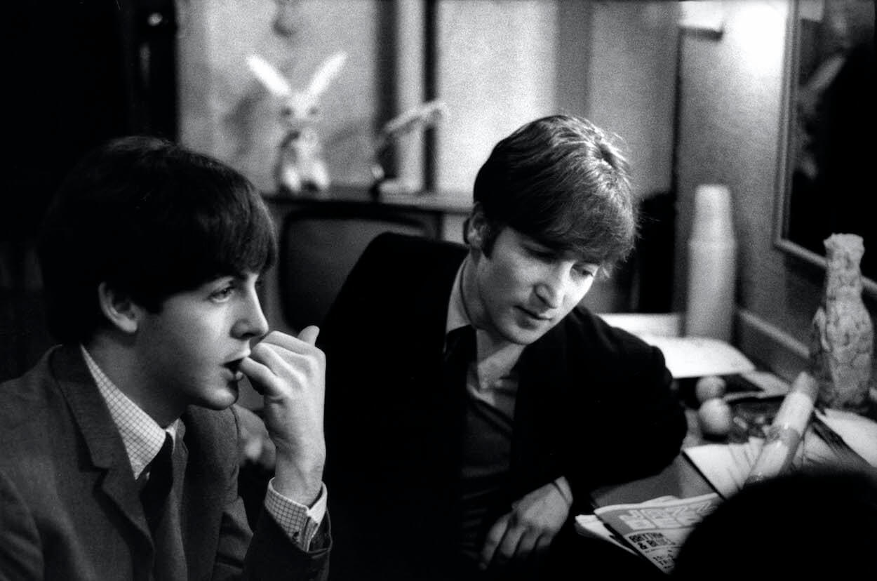 Paul McCartney (left) bites his hand as John Lennon looks down before a Beatles performance on Dec. 30, 1963.