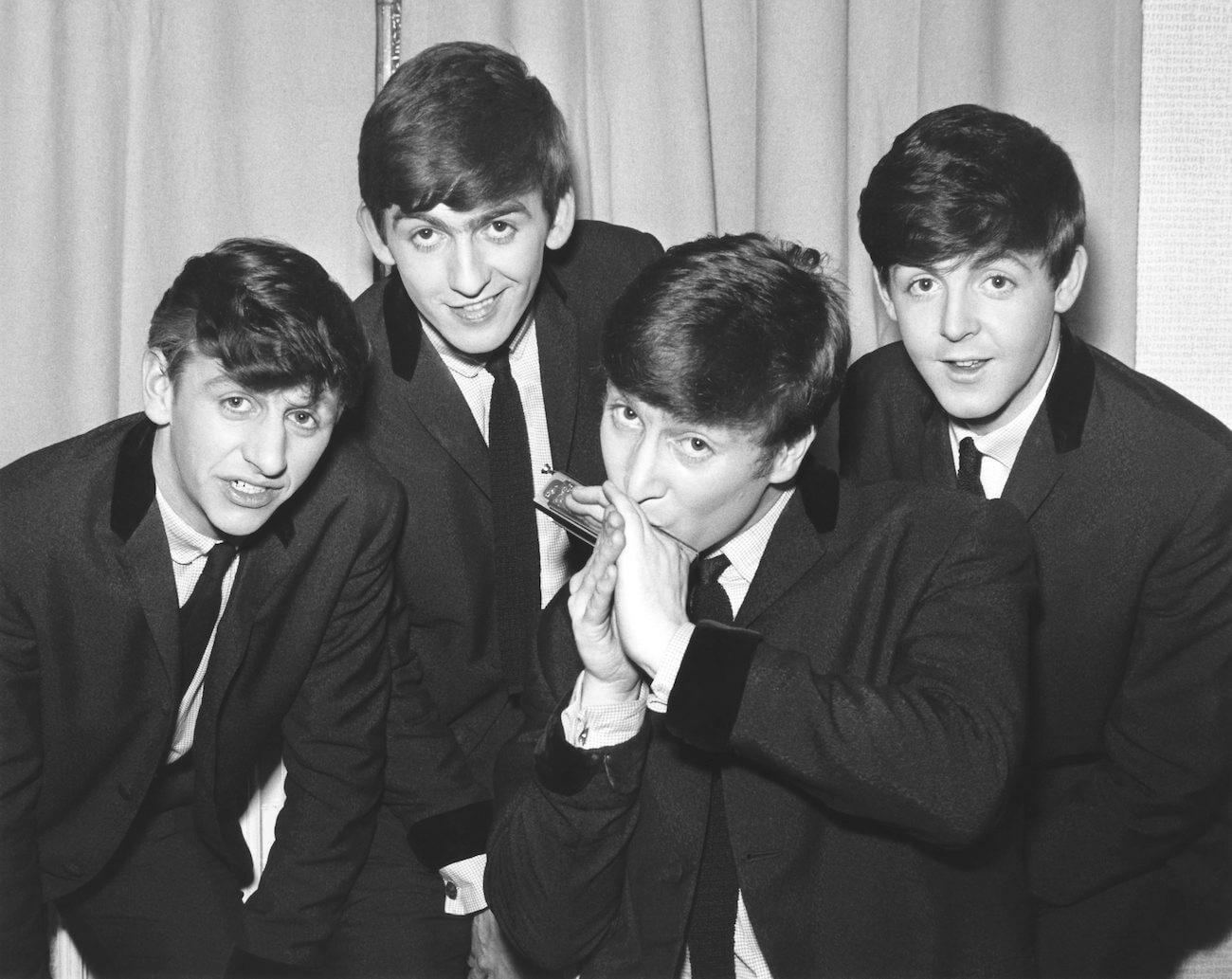 Paul McCartney and The Beatles in suits in 1962.