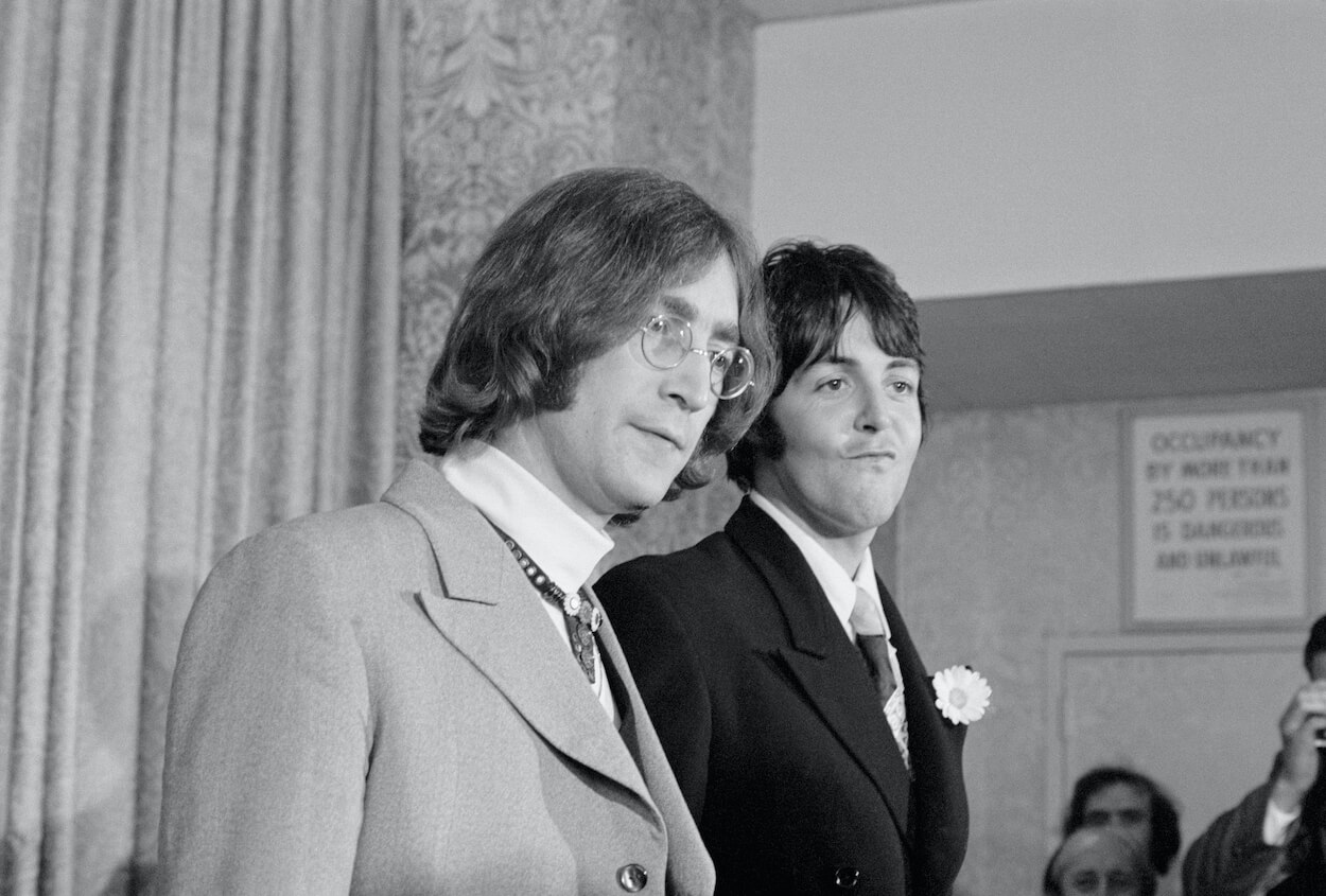 John Lennon (left) wears his glasses and a sport coat as he stands next to Paul McCartney during a 1968 press conference.