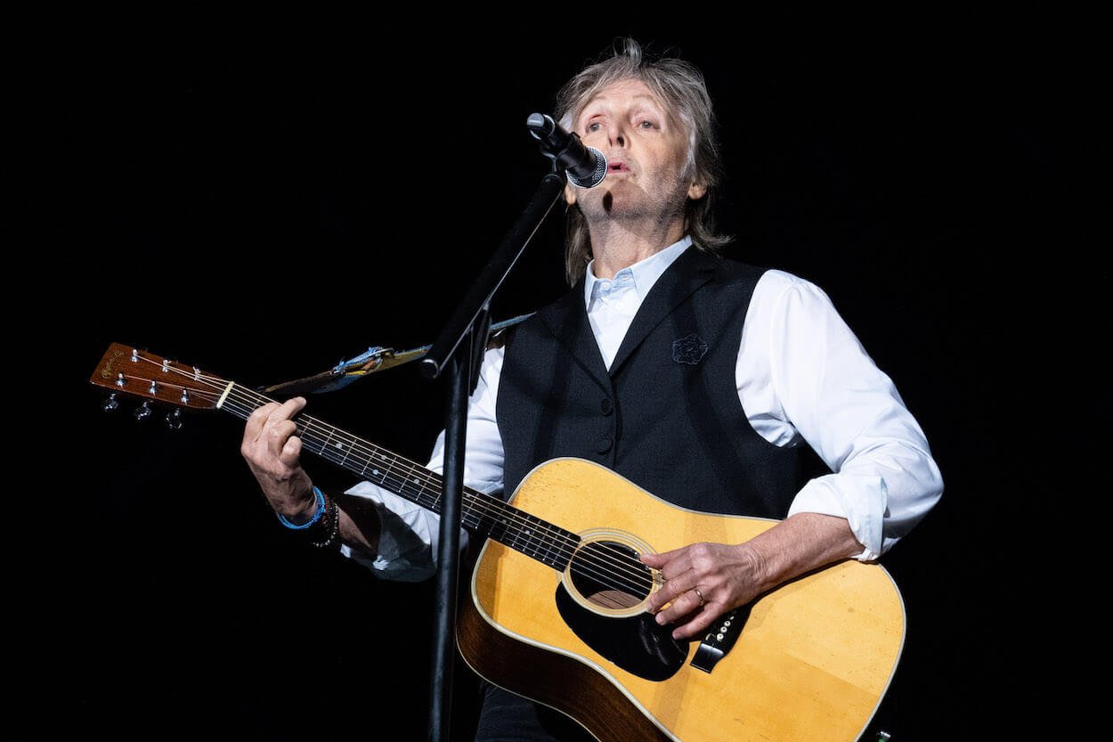 Paul McCartney strums an acoustic guitar while playing at the 2022 Glastonbury Festival in England.