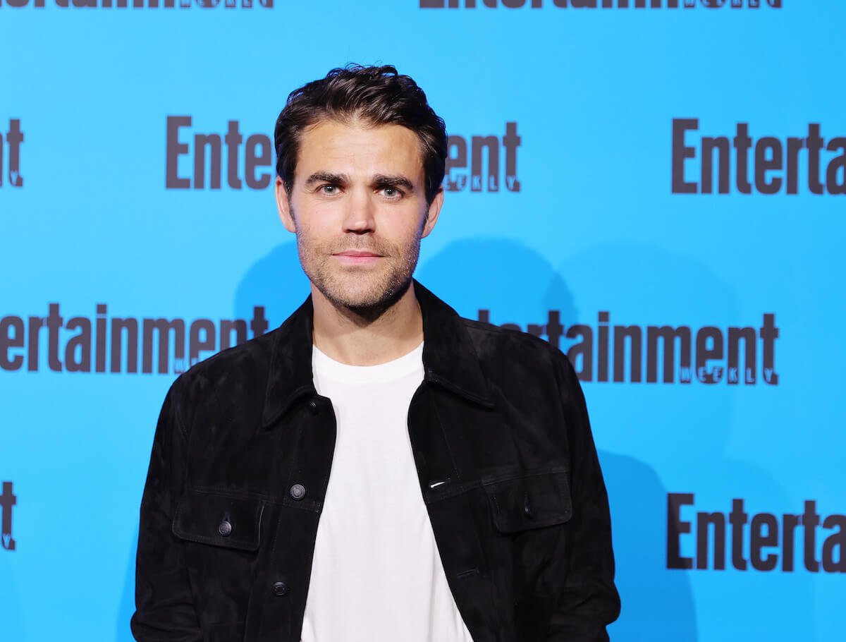 Paul Wesley with a serious face in front of a blue background