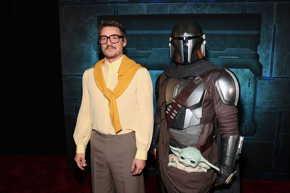 Pedro Pascal appears alongside a "Mandalorian" costumed character at a premiere event.