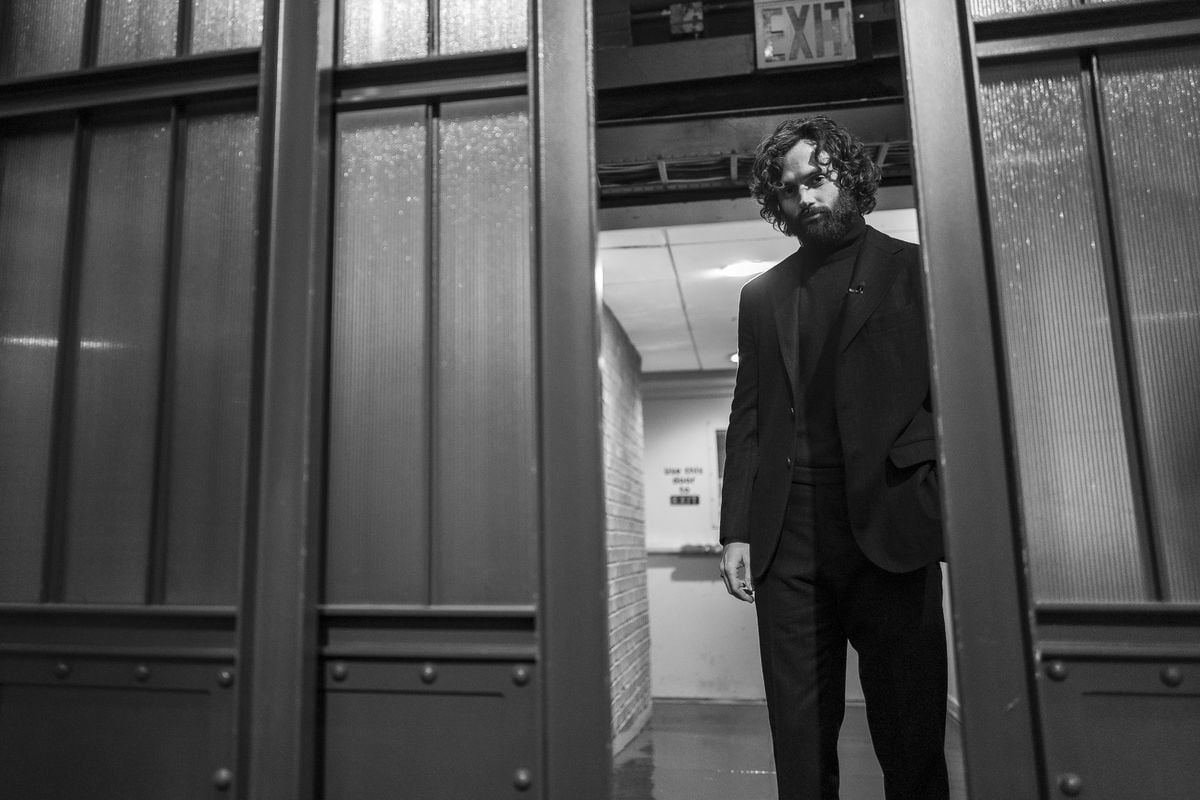 A black and white photo of Penn Badgley backstage at "Late Night With Seth Meyers"