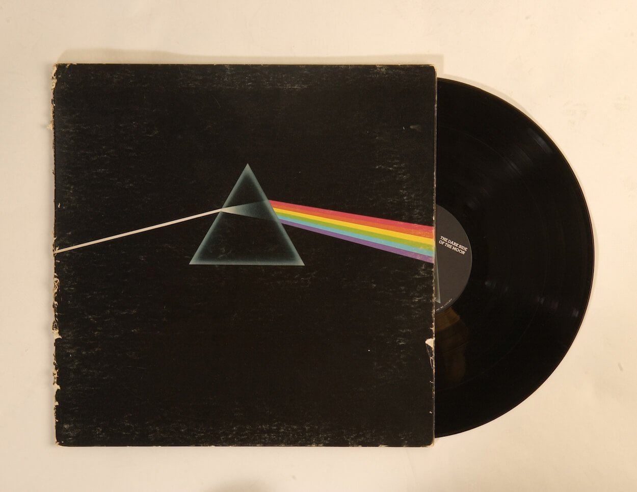 A drawing of a pyramid prism refracting a white beam of light into a rainbow on the album cover for Pink Floyd's 'The Dark Side of the Moon.'