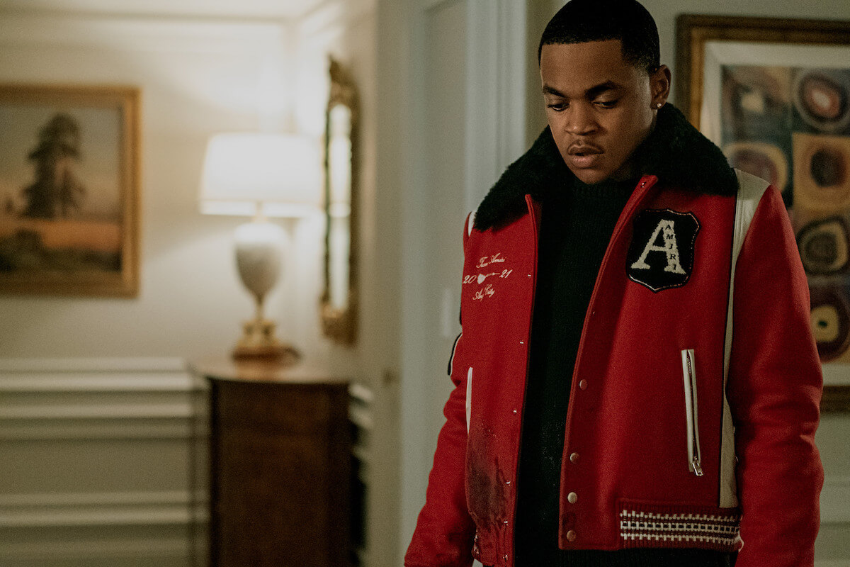 Michael Rainey Jr. as Tariq St. Patrick wearing a red letter man's jacket and staring at the floor in 'Power Book II: Ghost'