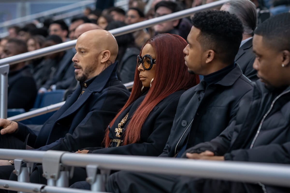Berto Colon as Lorenzo Tejada, Mary J. Blige as Monet Tejada, Lovell Adams Gray as Dru Tejada, and Woody McClain as Cane Tejada sitting in the stands wearing all black in 'Power Book II: Ghost'