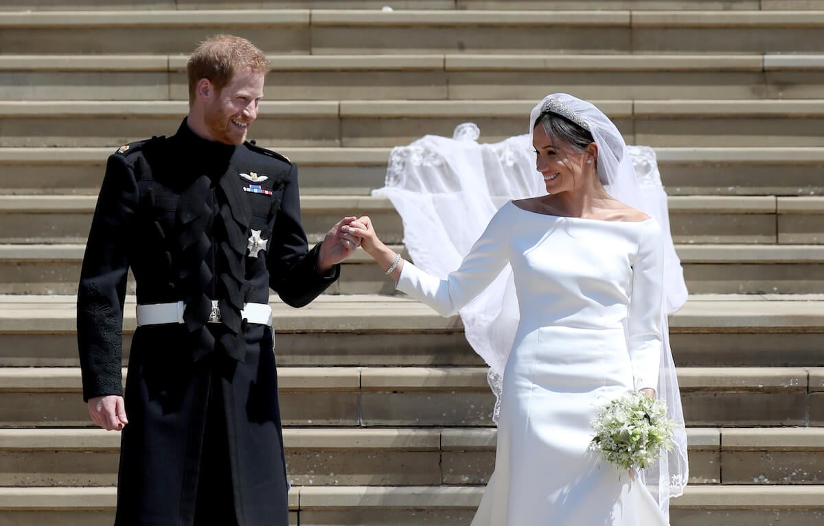 Prince Harry and Meghan Markle smiling and holding hands on their wedding day