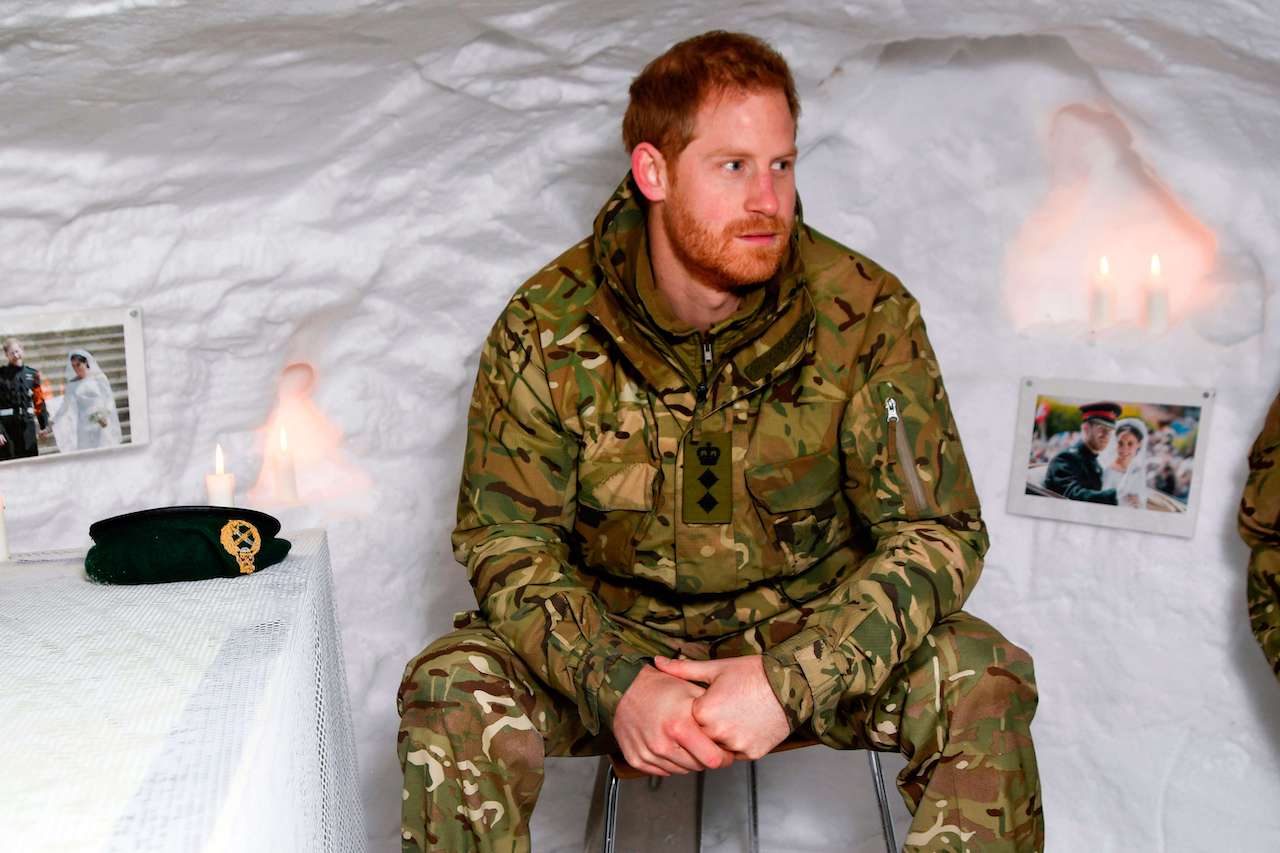 Prince Harry, Duke of Sussex, sits in a snow cave made by British military personnel and decorated with photos from his wedding on February 14, 2019, as he arrives at the military base of Bardufoss.