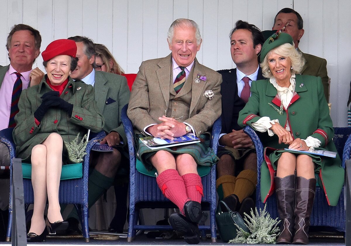 Princess Anne, King Charles III, and Camilla Parker Bowles laughing during the Braemar Highland Gathering