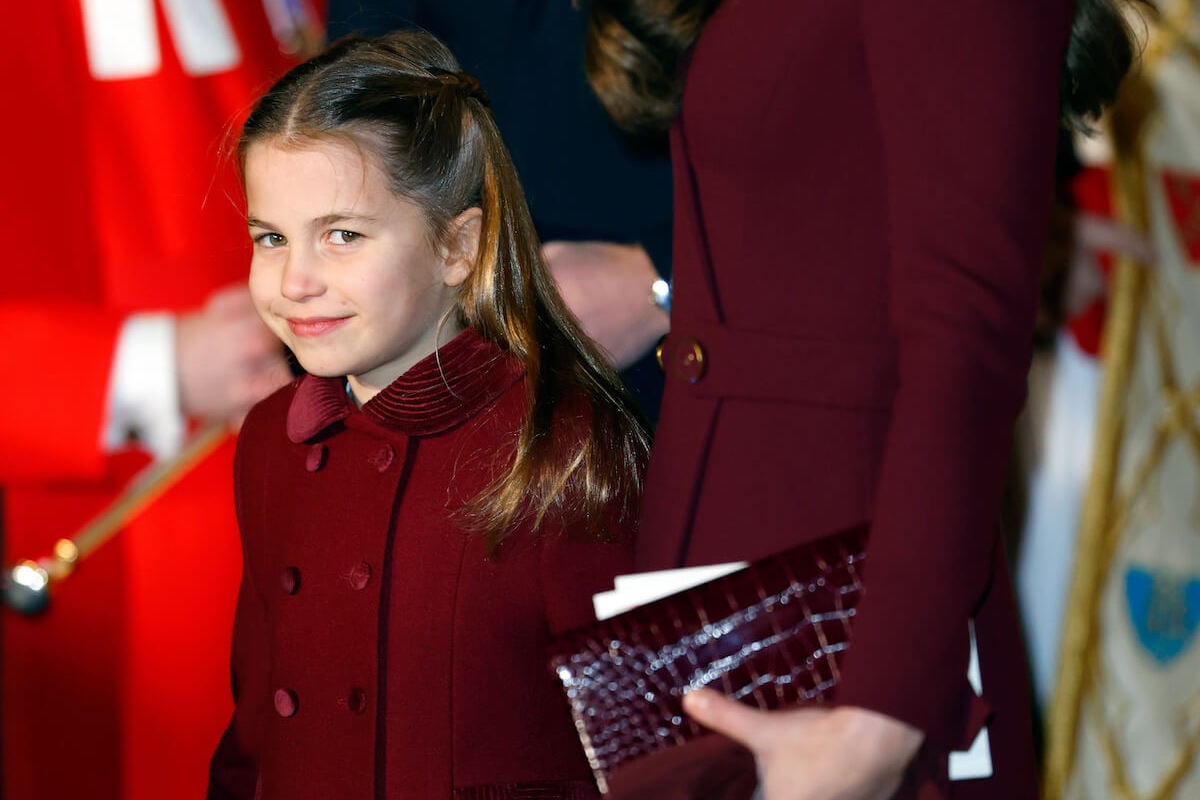 Princess Charlotte, whom a royal authors says is like Princess Anne, smiles and looks on