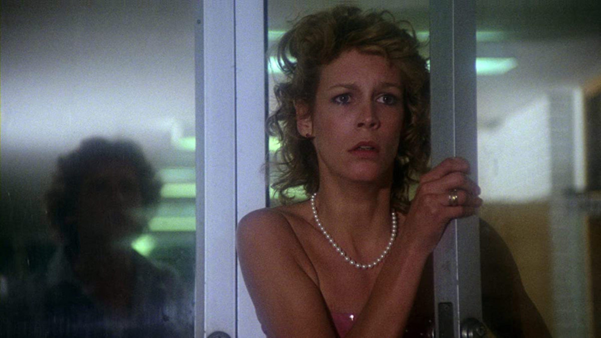 'Prom Night' Jamie Lee Curtis as Kimberly Hammond holding a door open looking scared.
