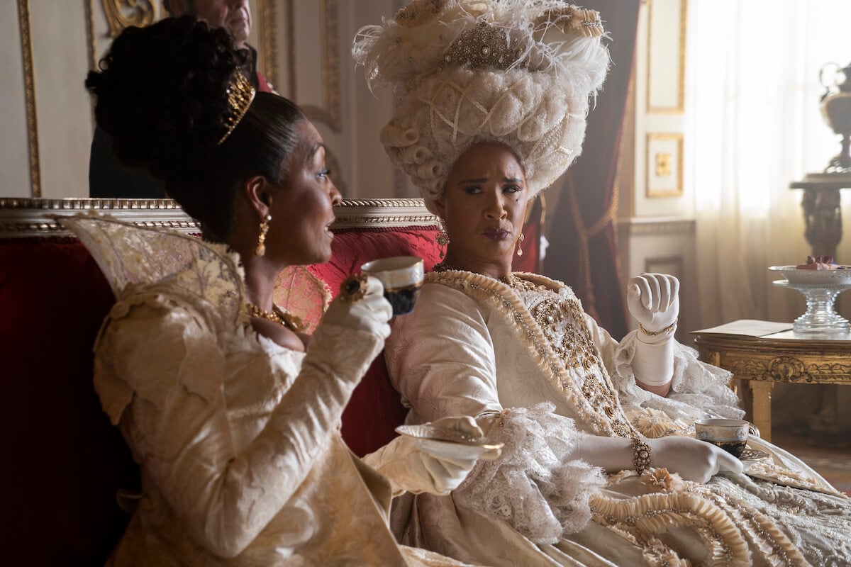 Adjoa Andoh as Lady Danbury and Golda Rosheuvel as Queen Charlotte dressed in creams and having tea in 'Bridgerton