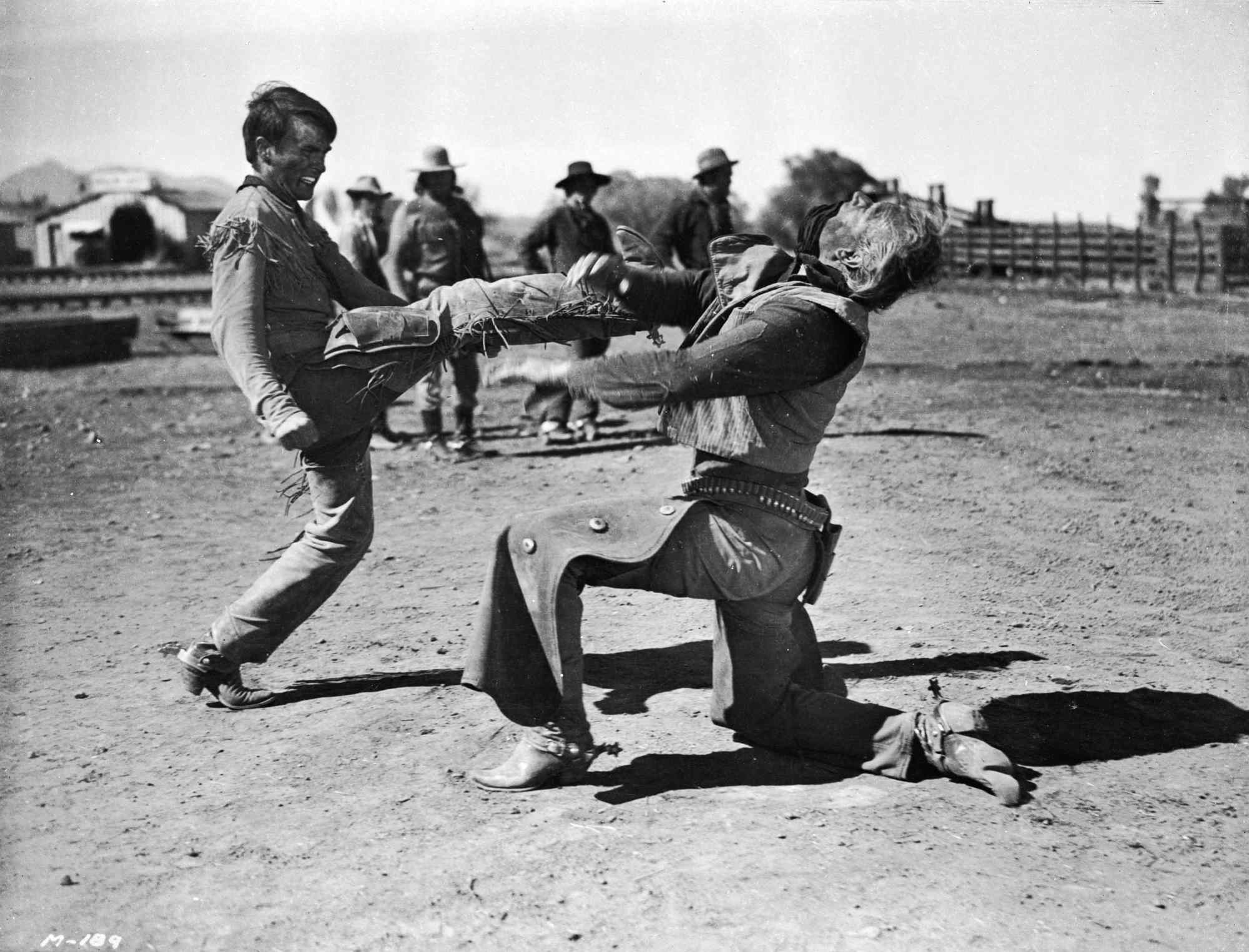 'Red River' Montgomery Clift as Matt Garth and John Wayne as Thomas Dunson. Matt kicks Thomas in the face, whose head is moving back.