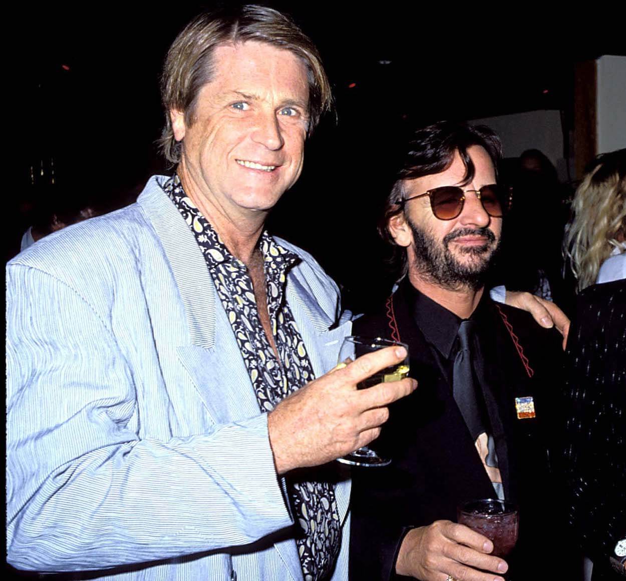 Brian Wilson (left) places his left arm around Ringo Starr during a 1990 party.