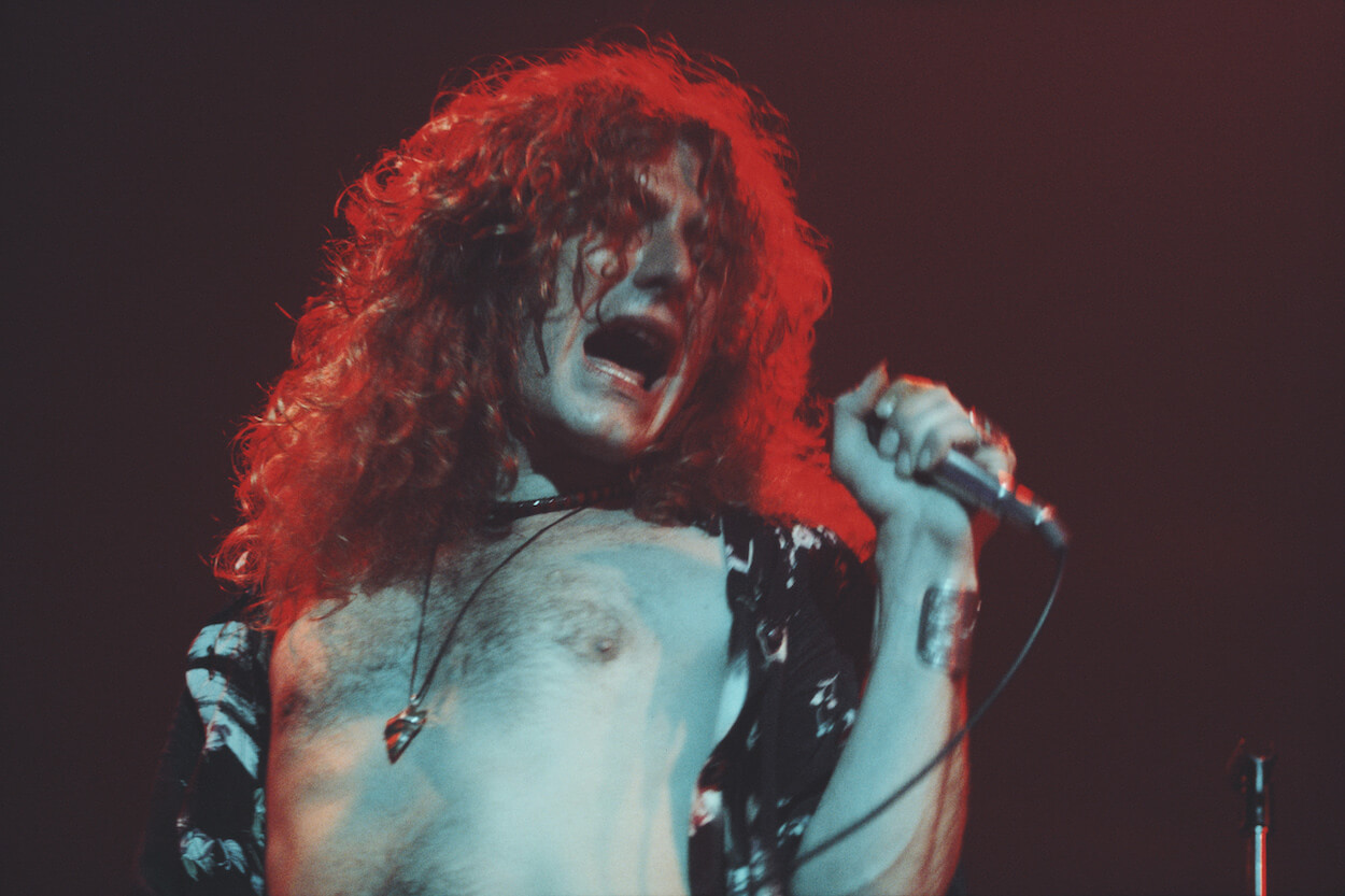 Led Zeppelin singer Robert Plant clutches a microphone in his left hand during a 1975 performance.
