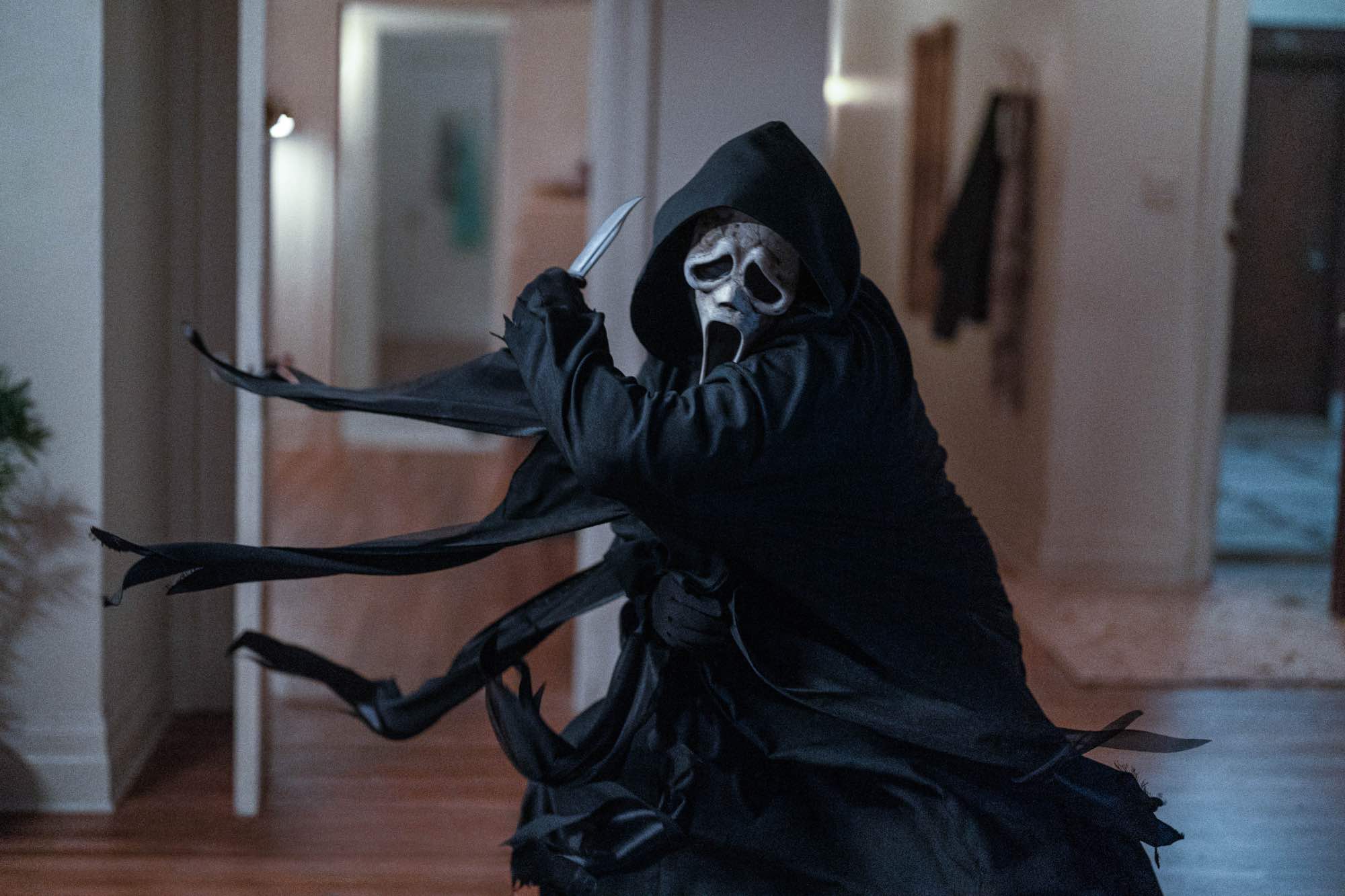 'Scream VI' Ghostface holding a knife, ready to slash in an apartment.