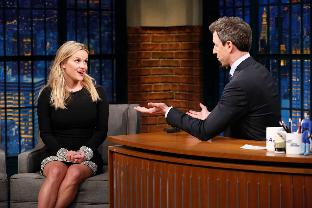 Reese Witherspoon and Seth Meyers facing each other, talking on 'Late Night With Seth Meyers'