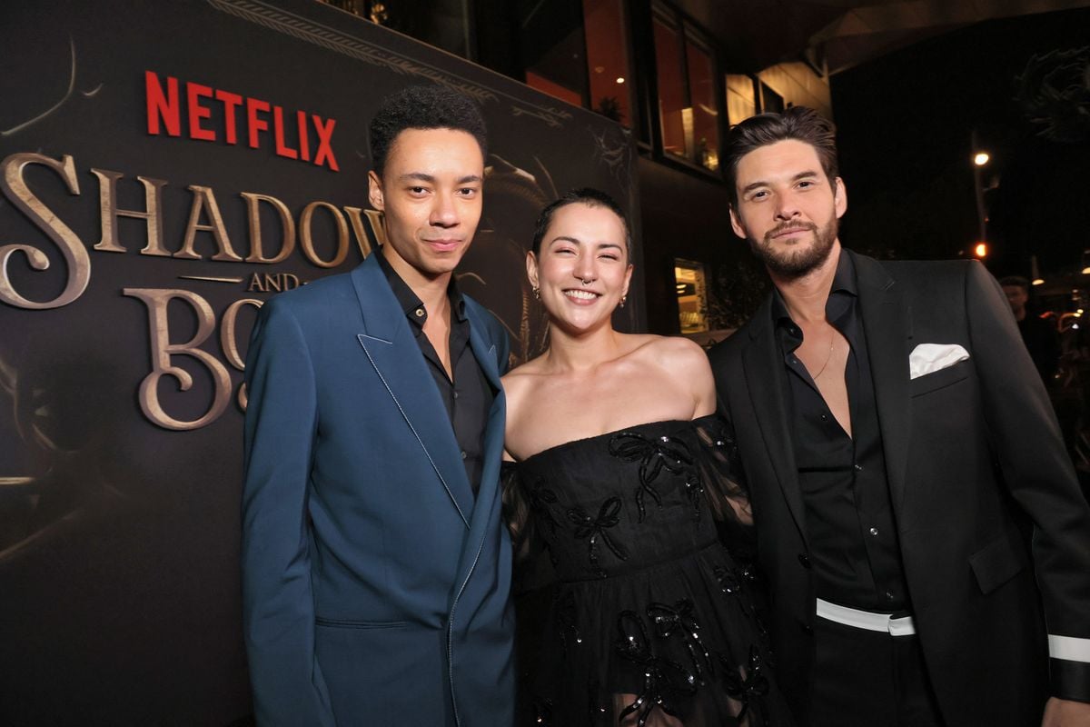 Kit Young, Jessie Mei Li and Ben Barnes pose for a photo in front of the "Shadow and Bone" logo.