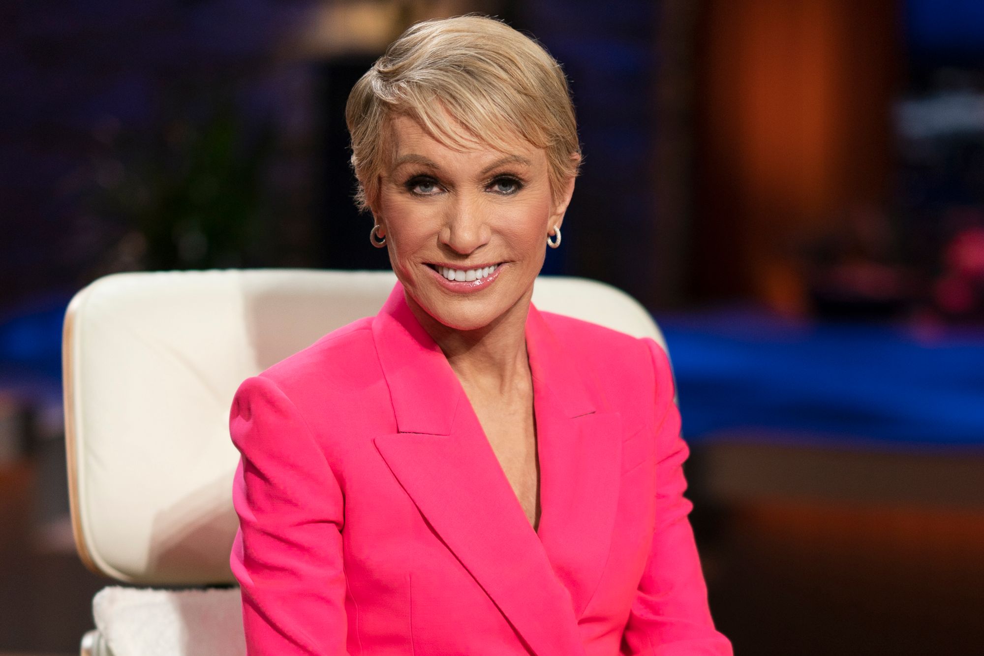 'Shark Tank' Barbara Corcoran, one of the sharks, smiling in a pink suit, while sitting in a white chair.