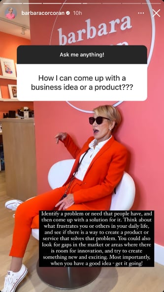 'Shark Tank' Barbara Corcoran wearing a red suit over a white dress shirt, sitting in a white chair against a salmon-colored wall.