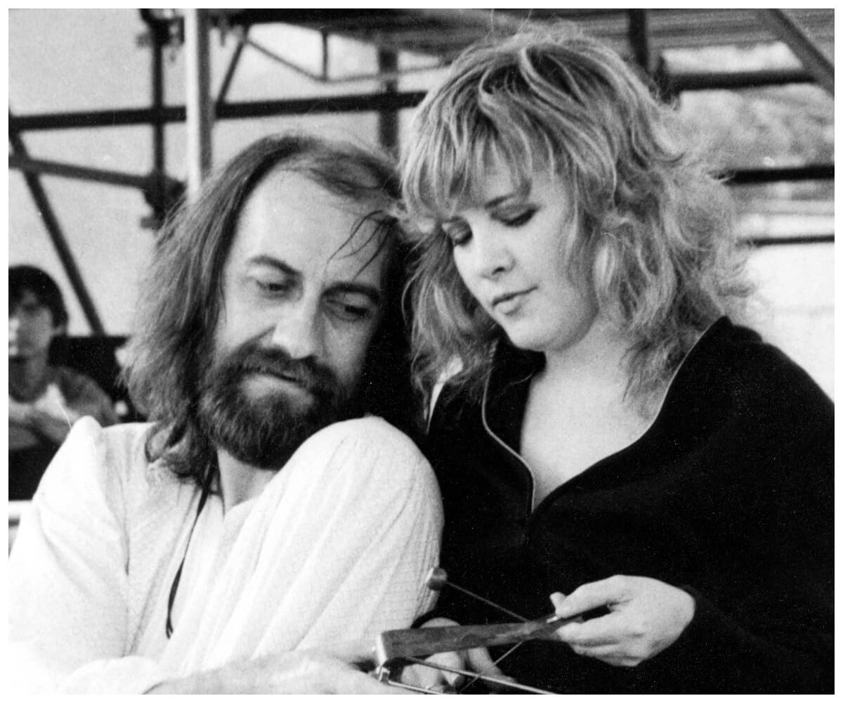 Black and white photo of Mick Fleetwood and Stevie Nicks standing close together in the early days of Fleetwood Mac.