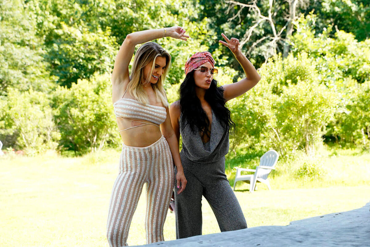 'Summer House' stars Danielle and Lindsay throw peace signs in the air in a production still from season 7.