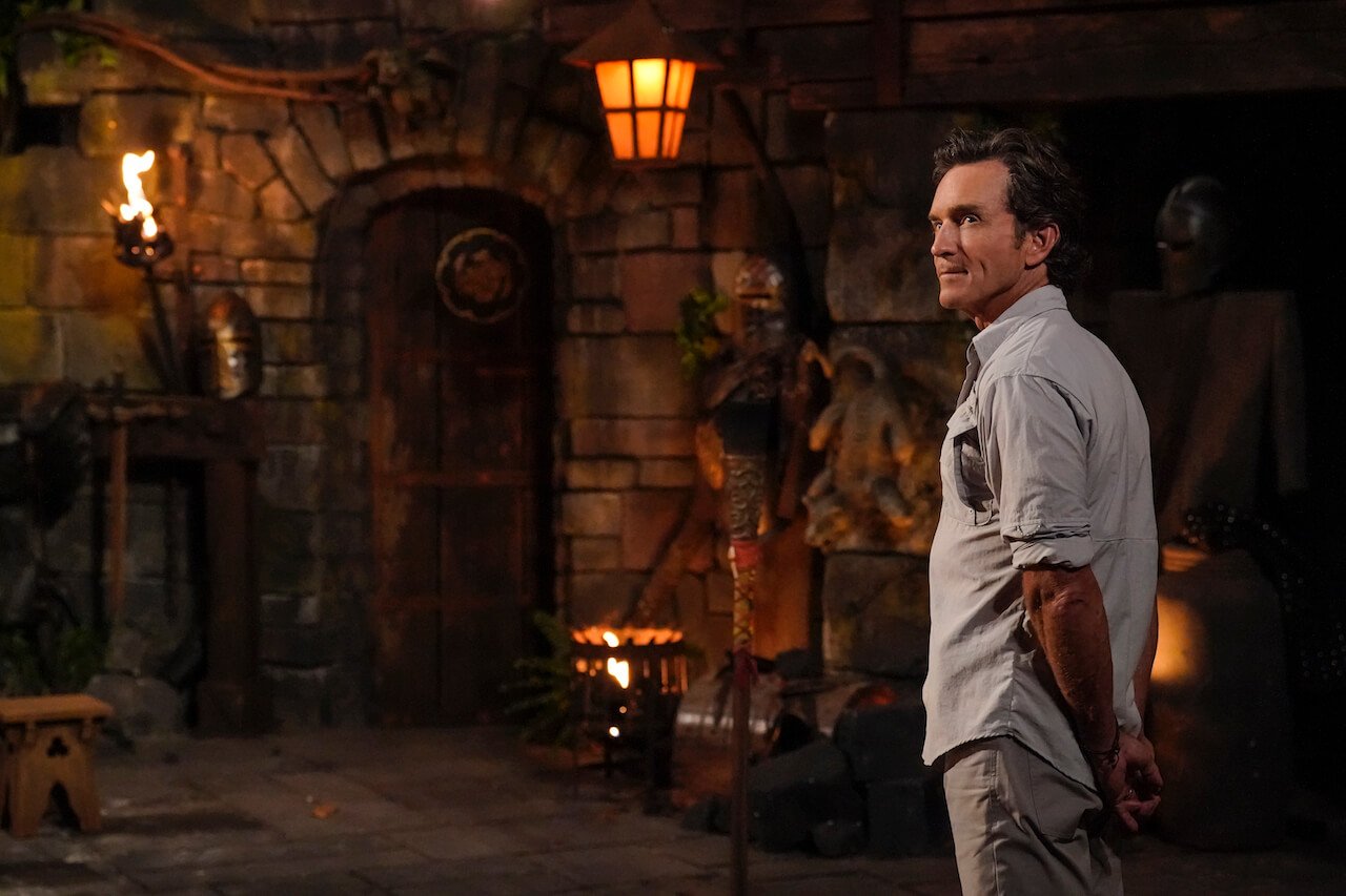 Jeff Probst stands at Tribal Council with his hands behind his back on 'Survivor 44'.