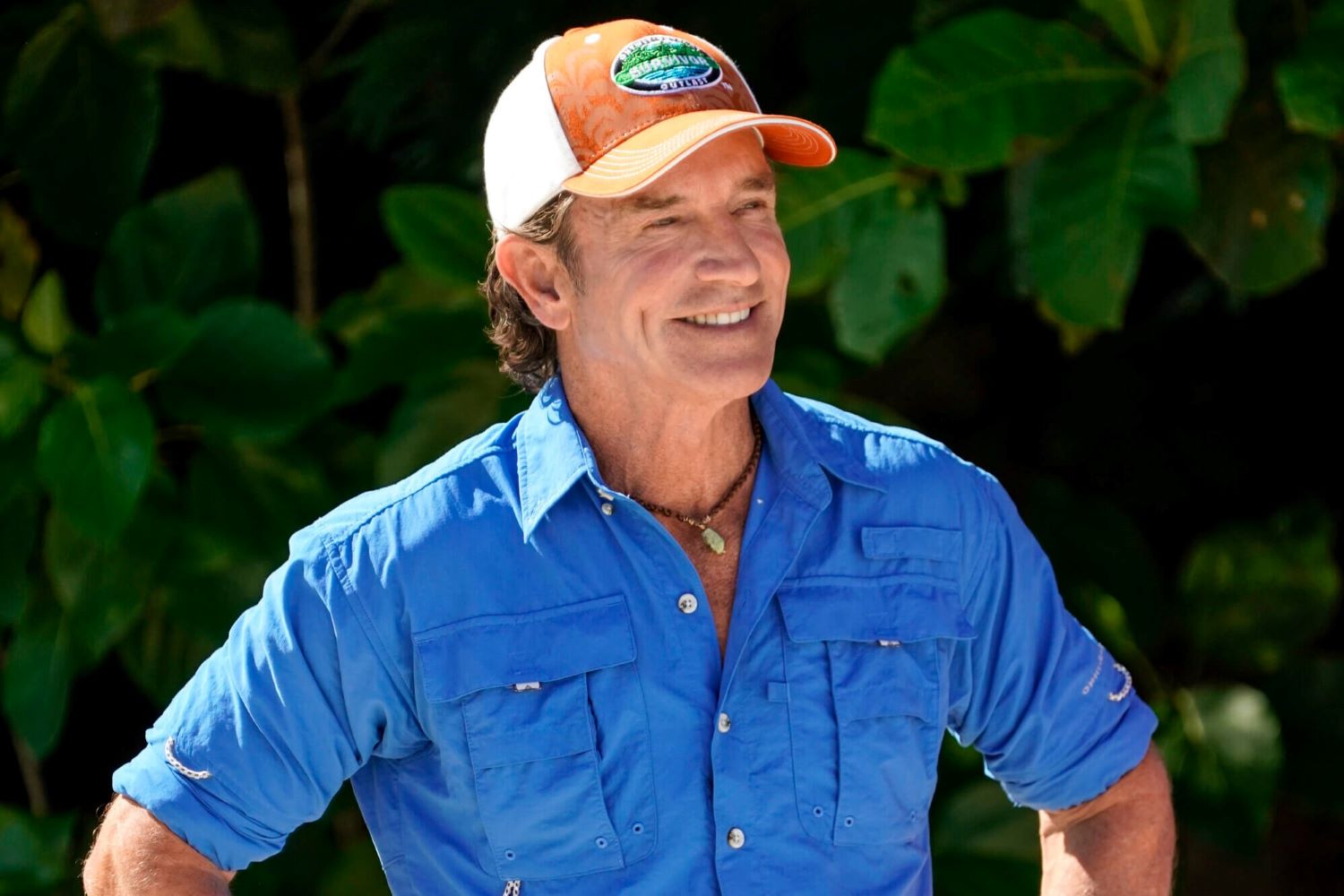 Jeff Probst, the host of 'Survivor' Season 44, which premieres tonight, wears a blue button-up shirt with rolled-up sleeves and an orange and white 'Survivor' baseball cap.