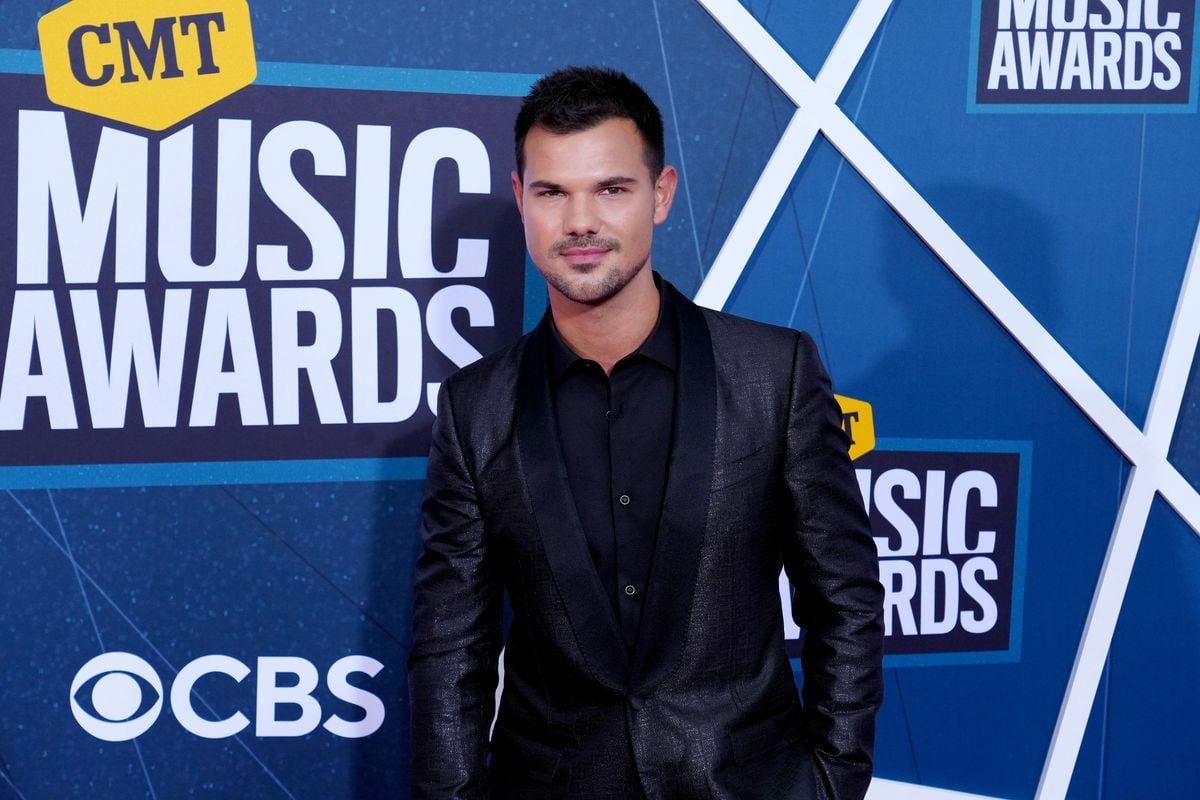 Taylor Lautner poses for photos at the CMT Music Awards red carpet.
