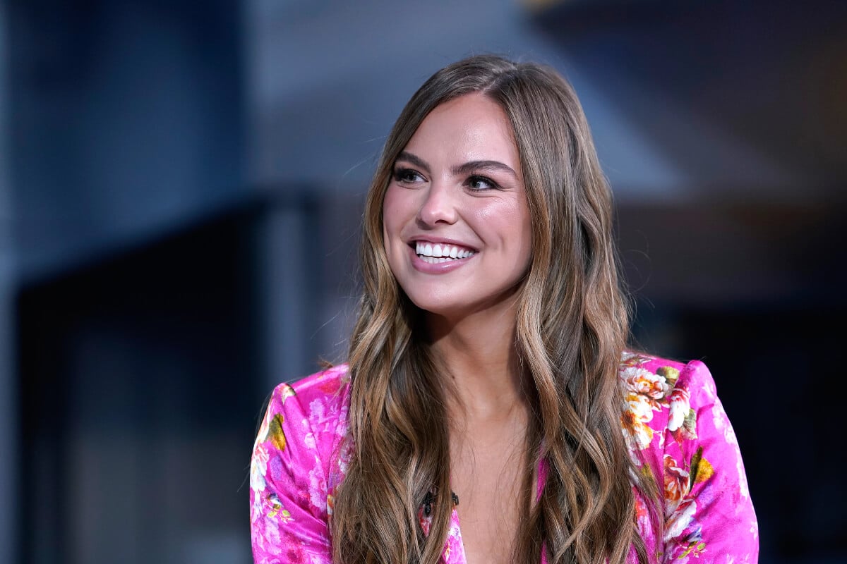 Former Bachelorette Hannah Brown wears a pink top and smiles.