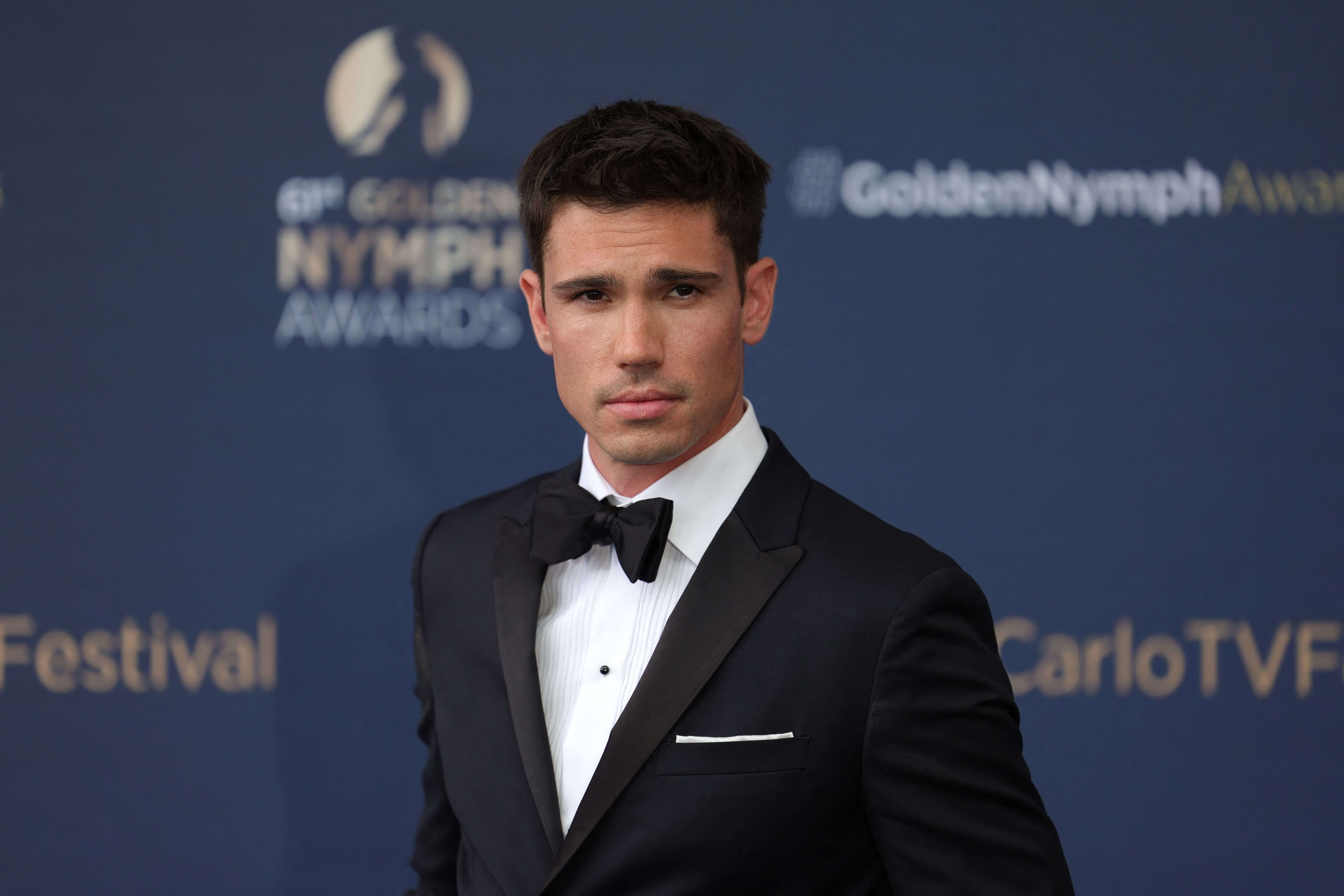 'The Bold and the Beautiful' star Tanner Novlan dressed in a tuxedo; posing on the red carpet.