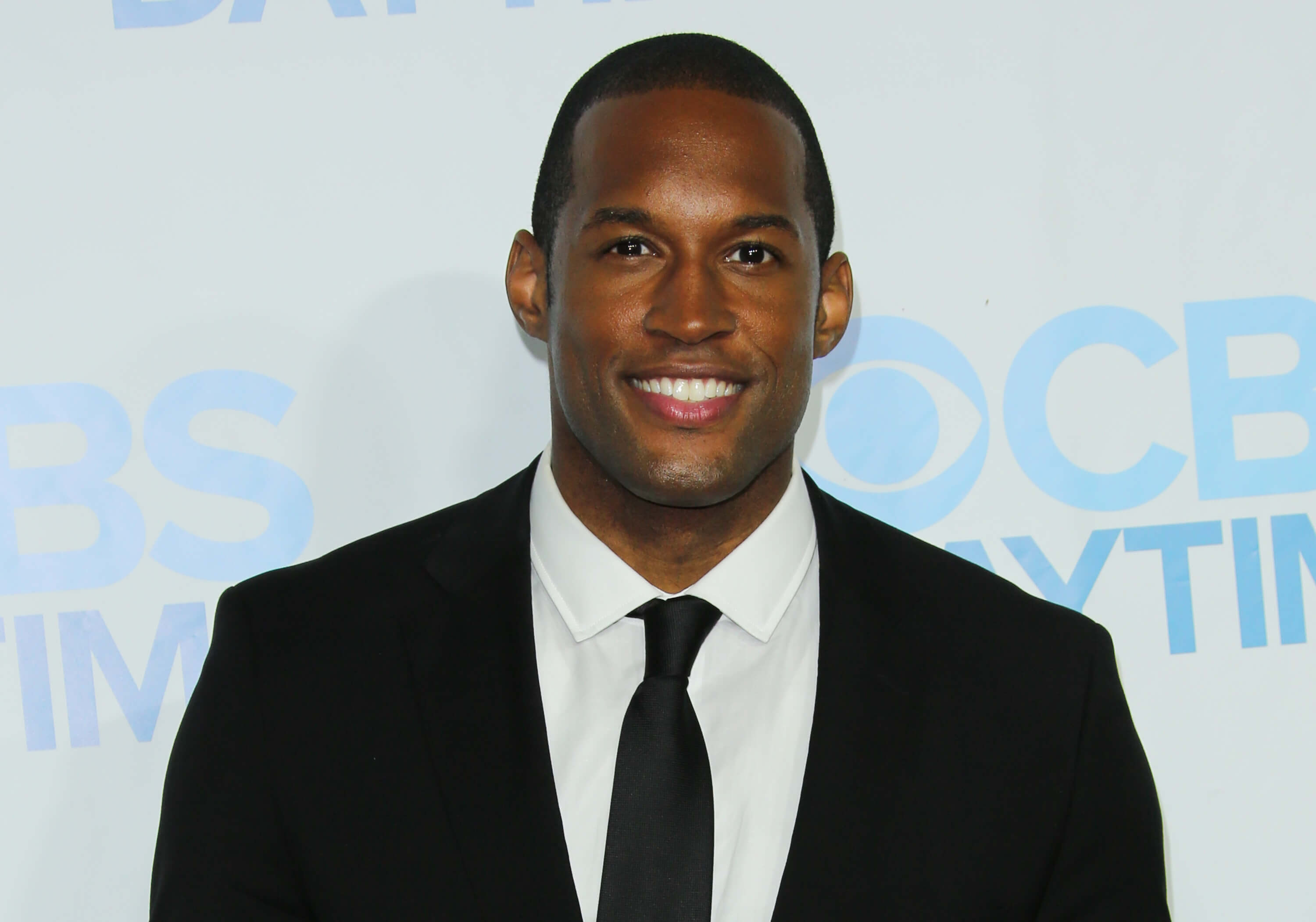 'The Bold and the Beautiful' star Lawrence Saint-Victor dressed in a tuxedo, smiling during a red carpet appearance.