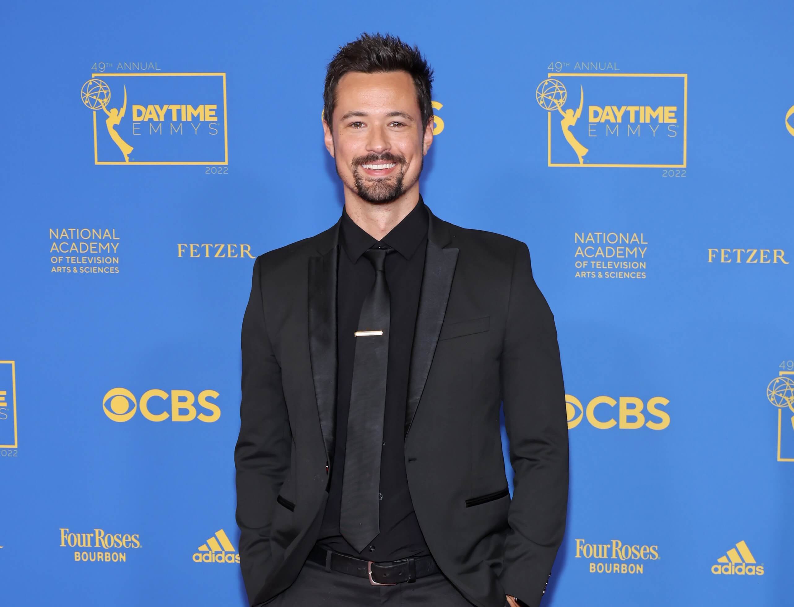 'The Bold and the Beautiful' star Matthew Atkinson dressed in a black suit; posing on the red carpet.