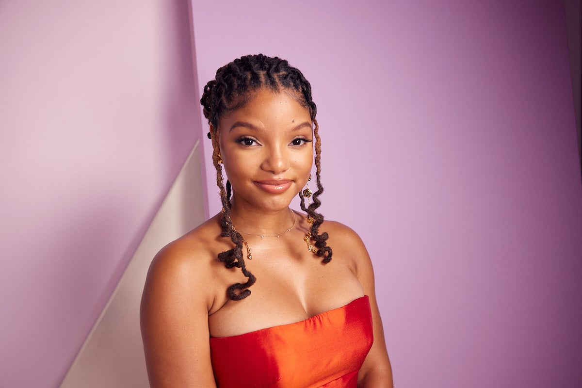 The Little Mermaid star Halle Bailey smiles in an orange gown