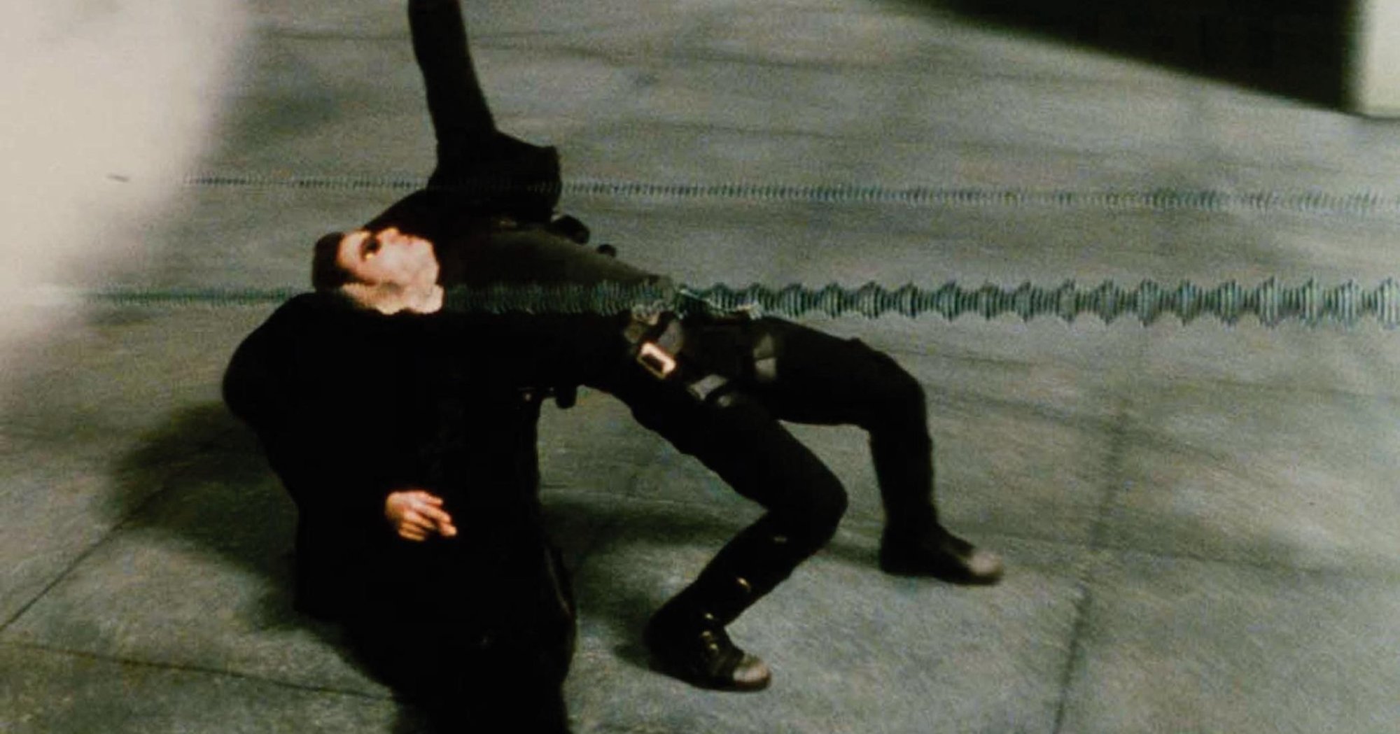 'The Matrix' Keanu Reeves as Neo dodging backward wearing all black, as bullets fly by.