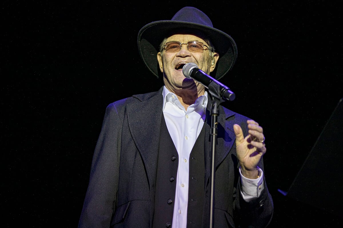 Micky Dolenz of The Monkees singing at a microphone