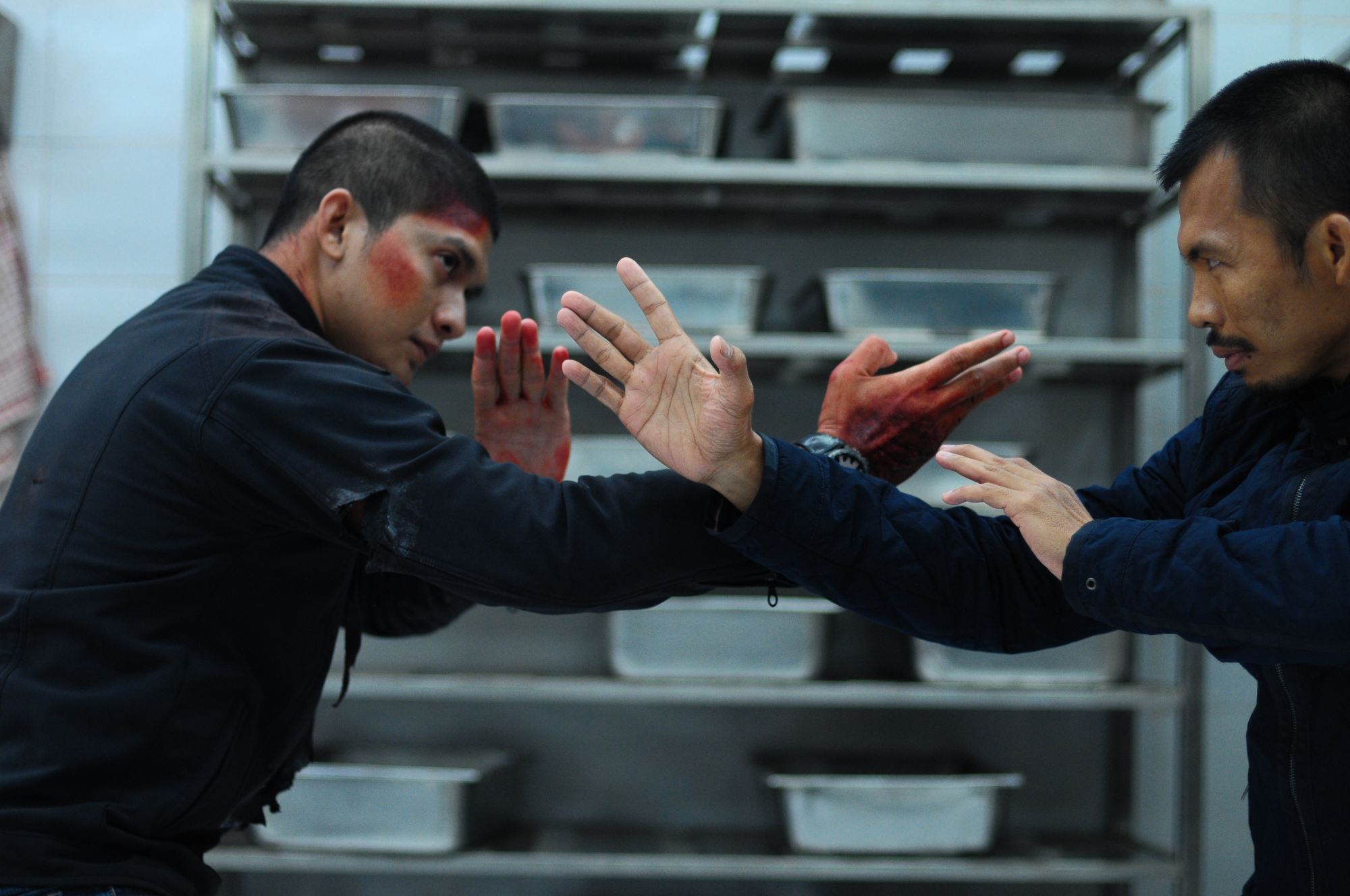 'The Raid 2' Iko Uwais as Rama and Cecep Arif Rahman as The Assassin holding their hands out in a fighting position, standing close to one another.