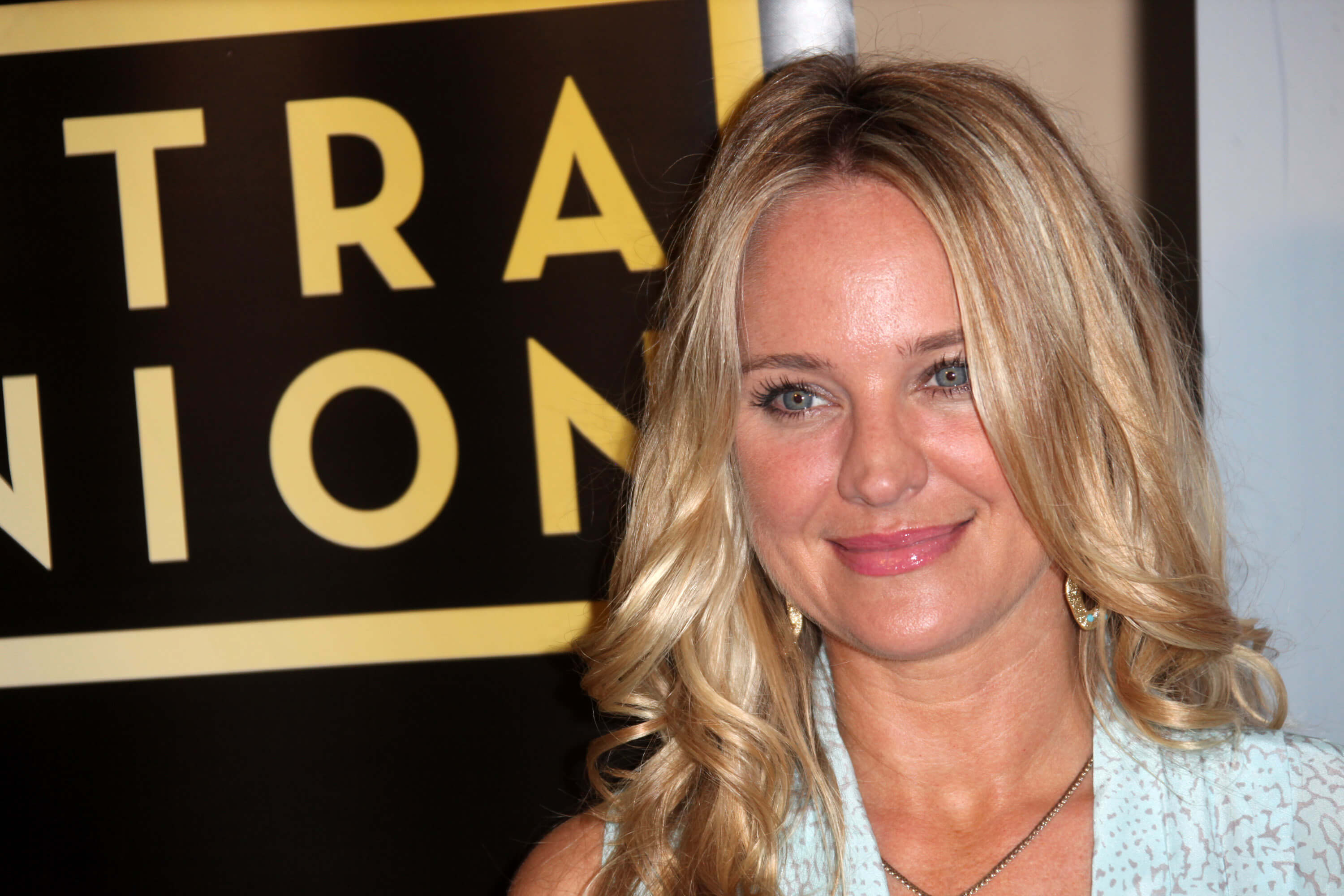 'The Young and the Restless' star Sharon Case dressed in a white outfit; smiling for a red carpet photo.